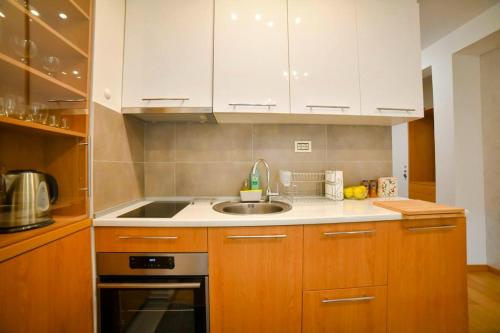 a kitchen with white cabinets and a sink at Apartman Silver Lux in Zlatibor