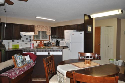 a kitchen with a table and a kitchen with a white refrigerator at Garden House in Courtenay
