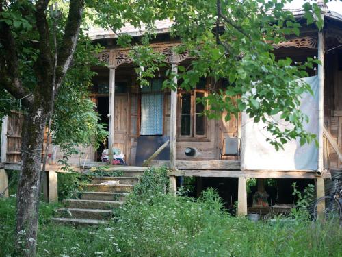 an old house with stairs leading to the front door at Mettavasi in Kutaisi