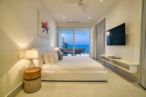 a bedroom with a bed and a view of the ocean at Maxwell Residences at Indah in Puerto Vallarta