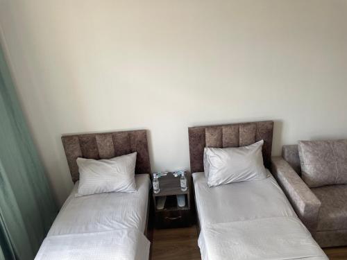 two beds in a room with a couch at Ruz & Arian Near Zvartnots Airport in Pʼarakʼar