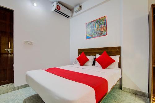 a bedroom with a large bed with red pillows at Hotel O Varcity Comforts Near St. John Medical College in Bengaluru