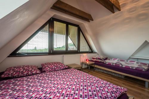 a bedroom with a large bed and two windows at Apartment Jamy in Tatranská Lomnica