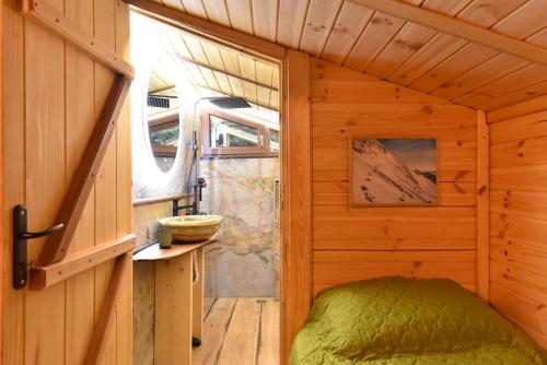 a small room with a bed in a wooden cabin at Life House-Semkovo in Semkovo