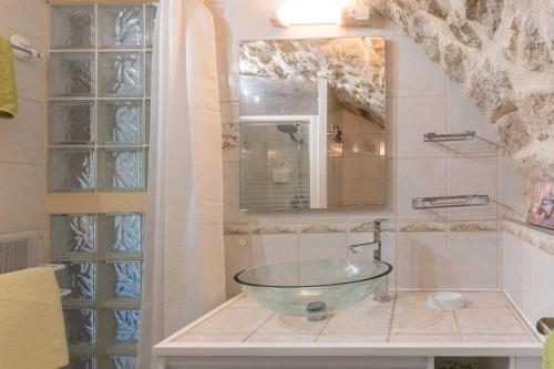 a bathroom with a glass bowl sink on a counter at Le Mas De La Blache in Payzac