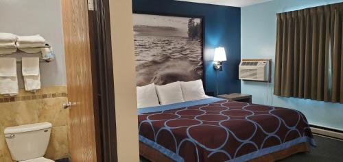 a hotel room with a bed and a bathroom at River Hill Inn & Suites in Hudson