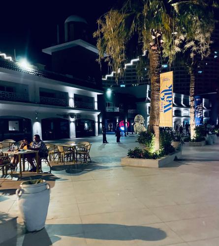 people sitting at tables in a courtyard at night at Porto El Sokhna Chalits In Water Front in Ain Sokhna