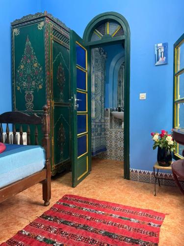 a bedroom with a green door and a red rug at Casa del Sol Marrakech in Marrakesh