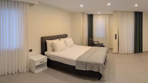 a bedroom with a bed and a chair in it at Villa Mare Luna & Villa Mariposa - Dream Luxury Summer Residences by the Aegean Sea in Marmaris