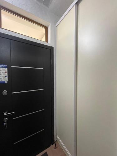 a black door in a room with a window at Cozy apartment in the center in Khmelʼnytsʼkyy