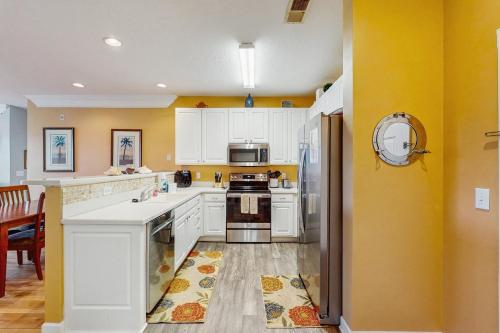 a kitchen with yellow walls and white cabinets at Friends Delight in Calabash