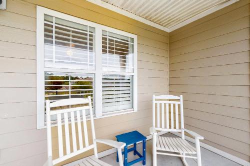 two rocking chairs on a porch with a window at Friends Delight in Calabash
