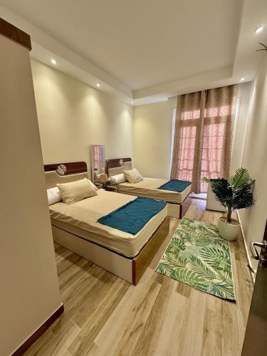 une chambre avec deux lits et un tapis dans l'établissement Alamein 2 bedroom الحي اللاتيني, à El Alamein