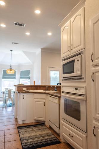 a kitchen with white cabinets and a microwave at Keller Haven in Keller