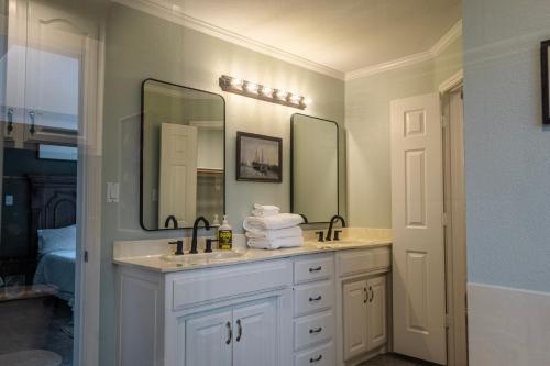 a bathroom with two sinks and two mirrors at Keller Haven in Keller