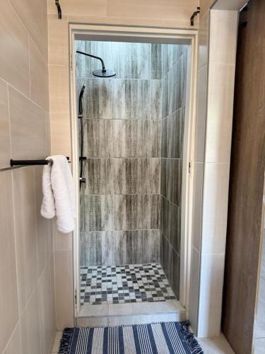 a shower with a glass door in a bathroom at House6705 Air B&B in Maun Airport