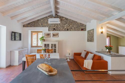 a living room with a table and a couch at Villetta Abbazia Acqua Dolce -With Stunning Terrace by Rent All Como in Lenno