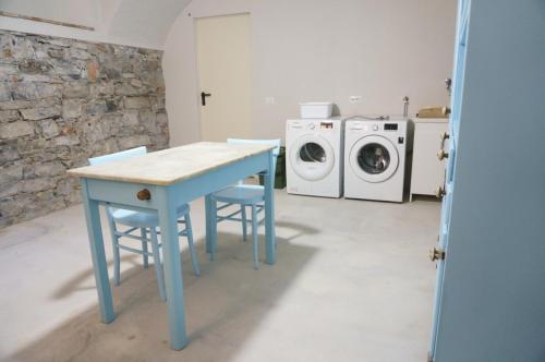 a blue table in a laundry room with a washing machine at Torno Design Apartment by Rent All Como in Torno