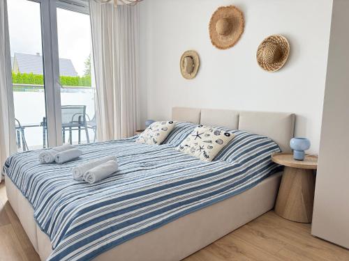 a bedroom with a bed with towels on it at Apartament Sunset Resort Grzybowo in Grzybowo