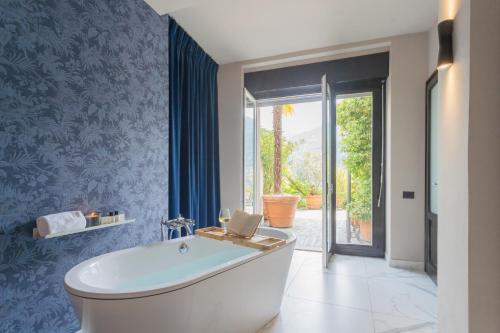 Vista Lario by Rent All Como في Carate Urio: حمام مع حوض ومرحاض ونافذة