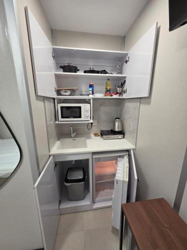 バト・ヤムにあるRyo 41 Studio apartment 5 minutes from the beachの小さなキッチン(白いキャビネット、電子レンジ付)