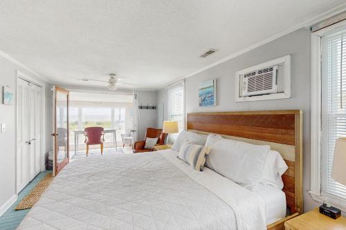 a bedroom with a large white bed with a wooden headboard at Moonlighting in Edisto Beach