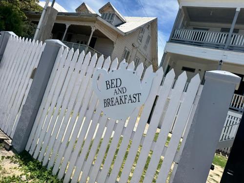 a white picket fence in front of a house at The Ambassador's Terrace in Belize City