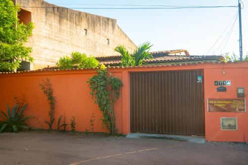 an orange building with a gate in front of it at Casa de Hospedagem Cajueiro in Jijoca de Jericoacoara