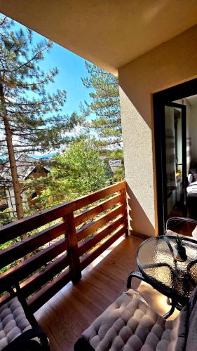 a balcony with a table and chairs on a deck at Apartman Silver Lux in Zlatibor