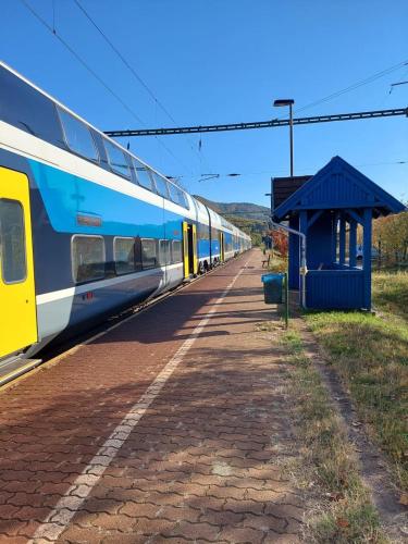 a blue and white train parked at a train station at Erdőszéli Vendégház Zebegény in Zebegény