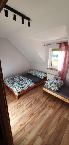 a room with two beds and a window at Biały Źagiel in Jantar