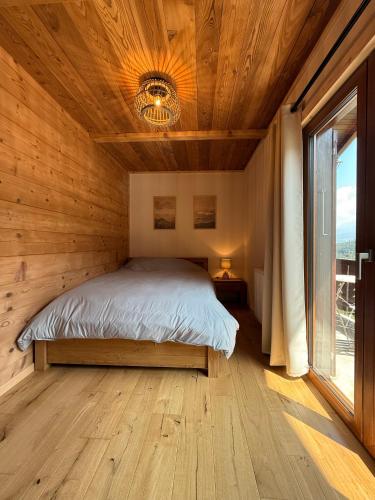 a bedroom with a bed in a wooden cabin at Chalet cosy au pied des Portes du Soleil in Troistorrents