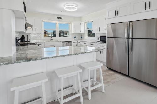 a kitchen with white cabinets and a stainless steel refrigerator at 8720 - Beach Please (Frisco) in Frisco