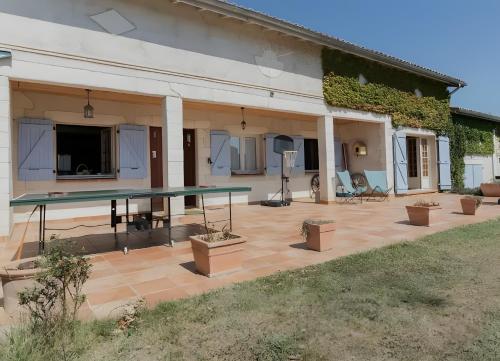 a ping pong table on a patio outside of a house at Grand Gite De Gascogne - 12 Places 
