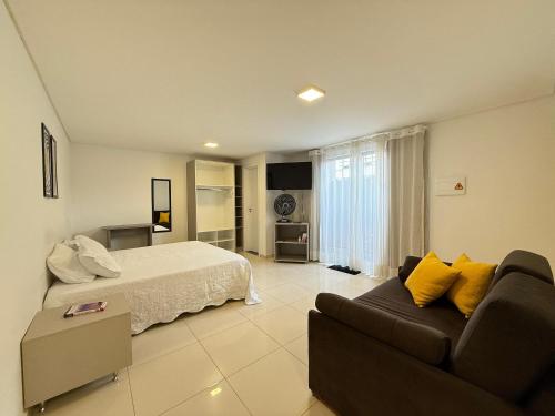 a large bedroom with a bed and a couch at Studio Charmoso Próximo ao Parque do Lago - SPMA01 in Guarapuava