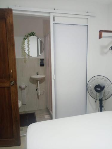 a bathroom with a shower and a sink with a fan at KOKOA GARDEN INN in San Vicente de Chucurí