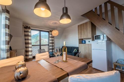 eine Küche und ein Esszimmer mit einem Tisch und einem Kühlschrank in der Unterkunft Apartment Stella in Tatranská Lomnica