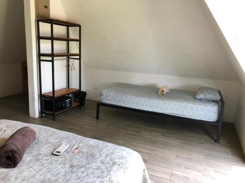 a bedroom with two beds and a book shelf at Pyramid Tamarindo Luxury Hotel in Tamarindo