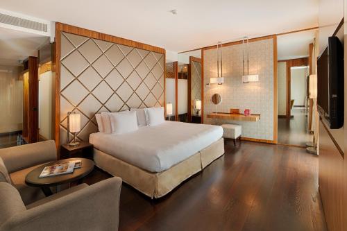 a bedroom with a bed and a living room at NH Collection Taormina in Taormina