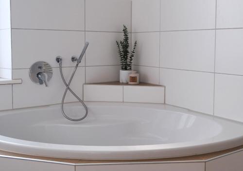 eine weiße Badewanne mit Dusche im Badezimmer in der Unterkunft CASA LUXE - 110qm - Stadtmitte - Familienfreundlich - Parkplatz - 5km zum Legoland in Günzburg