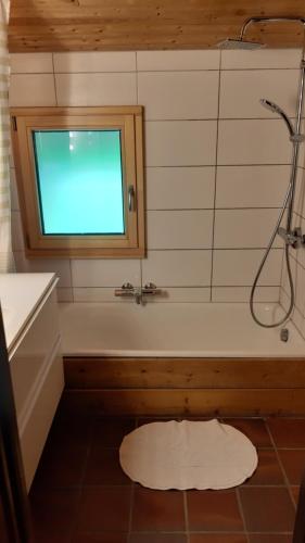 a bathroom with a shower and a tub with a window at Chalet familial au cœur de la Haute Savoie in La Roche-sur-Foron