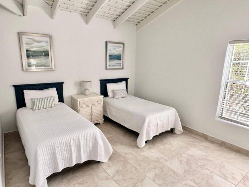 a bedroom with two beds and a window at Beautiful 4 Br3 Ba South Sound Home Wpool in George Town