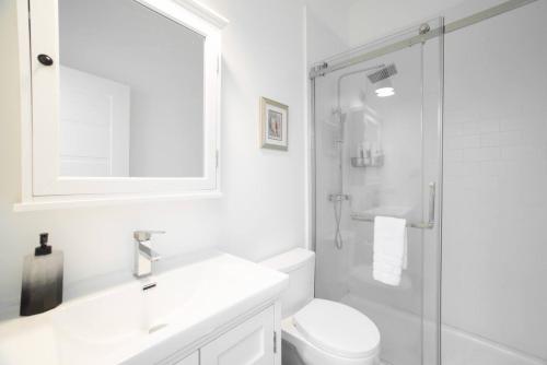 a white bathroom with a sink and a shower at Seamist 308 Views Of North Sound in West Bay