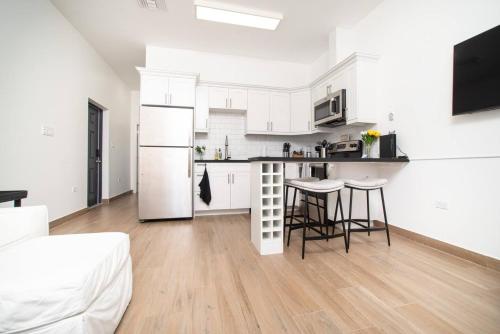 a kitchen with white cabinets and a table and chairs at Seamist 308 Views Of North Sound in West Bay