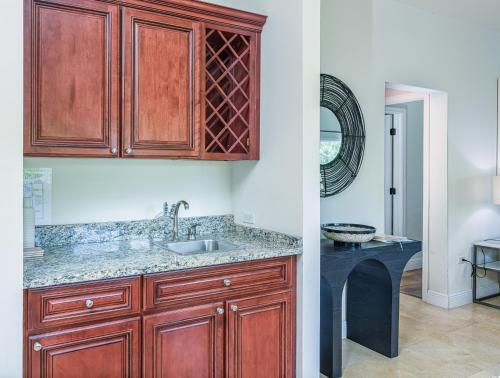 a kitchen with wooden cabinets and a sink at Windsong #4 On Boggy Sand Road Steps From Smb in West Bay