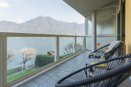 a balcony with two chairs and a view of the water at Besana 9 on the Lake - Private garden & parking by Rent All Como in Moltrasio