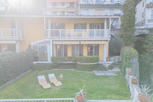 a house with a yard with benches in front of it at Besana 9 on the Lake - Private garden & parking by Rent All Como in Moltrasio