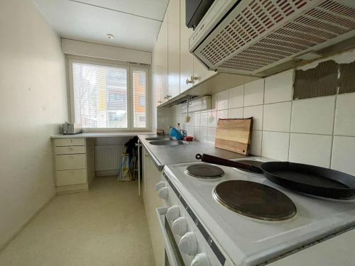 a kitchen with a stove and a sink at Ground floor 3 bedroom apartment, free parking in Oulu