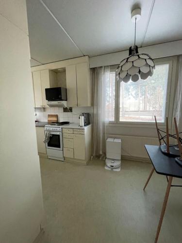a kitchen with white cabinets and a window at Ground floor 3 bedroom apartment, free parking in Oulu