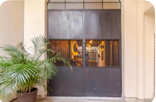 a black door with plants in front of a building at LA HIDALGO Departamento 3 in Chapala